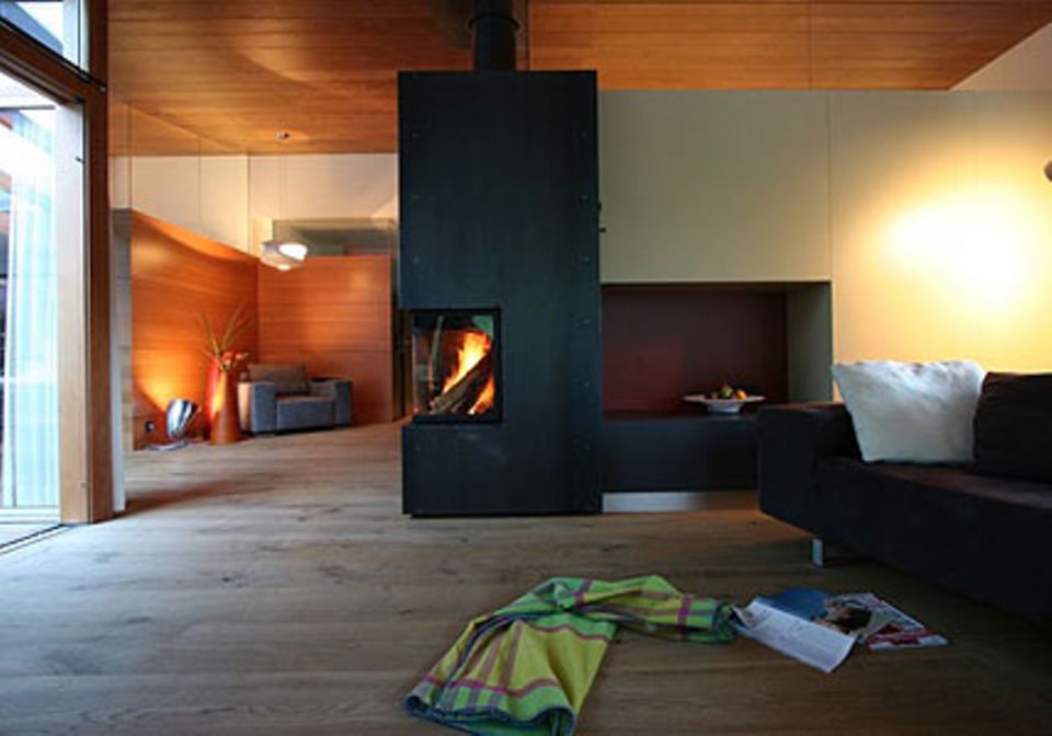 Warmes Holz, puristische Formen und ein eigener Kamin erwarten die Gäste in den Suiten.