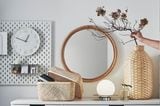 Schön dekoriertes Sideboard von Ikea mit einem Spiegel, Korb, einer Vase, Wanduhr und vielem mehr