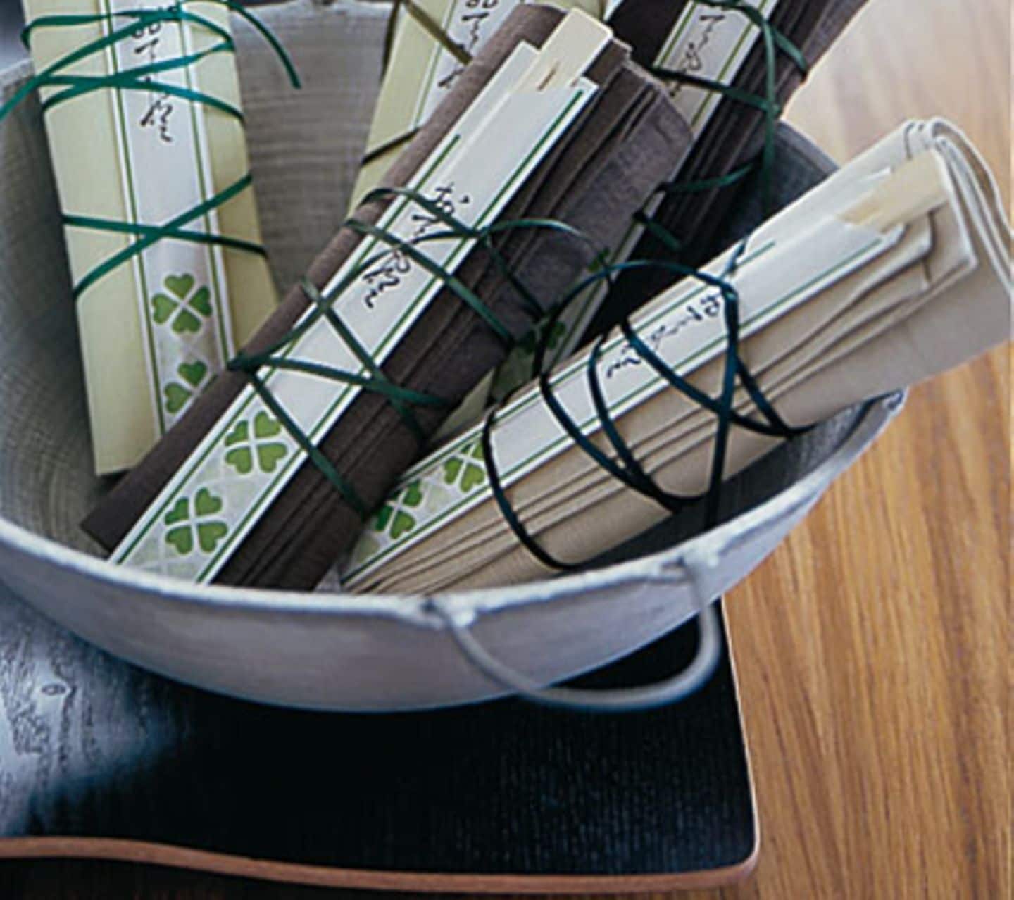 Ein mit Stäbchen verzierter Gutschein für ein asiatischen Essen ist in einer Serviette verpackt