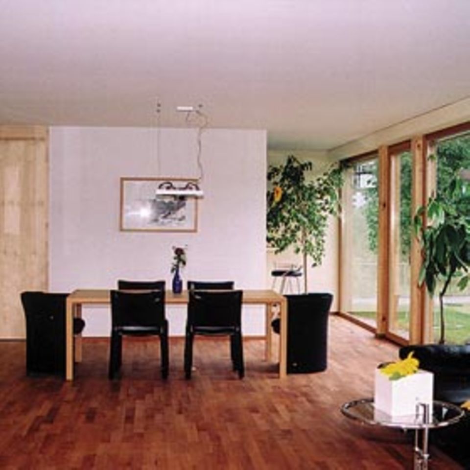 Holzmodulhaus in Dornbirn: Die Hölzer Birnbaum und Ahorn dominieren im Inneren. Viel Licht gelangt durch hohe Fenster in den klar gegliederten großen Wohnraum.