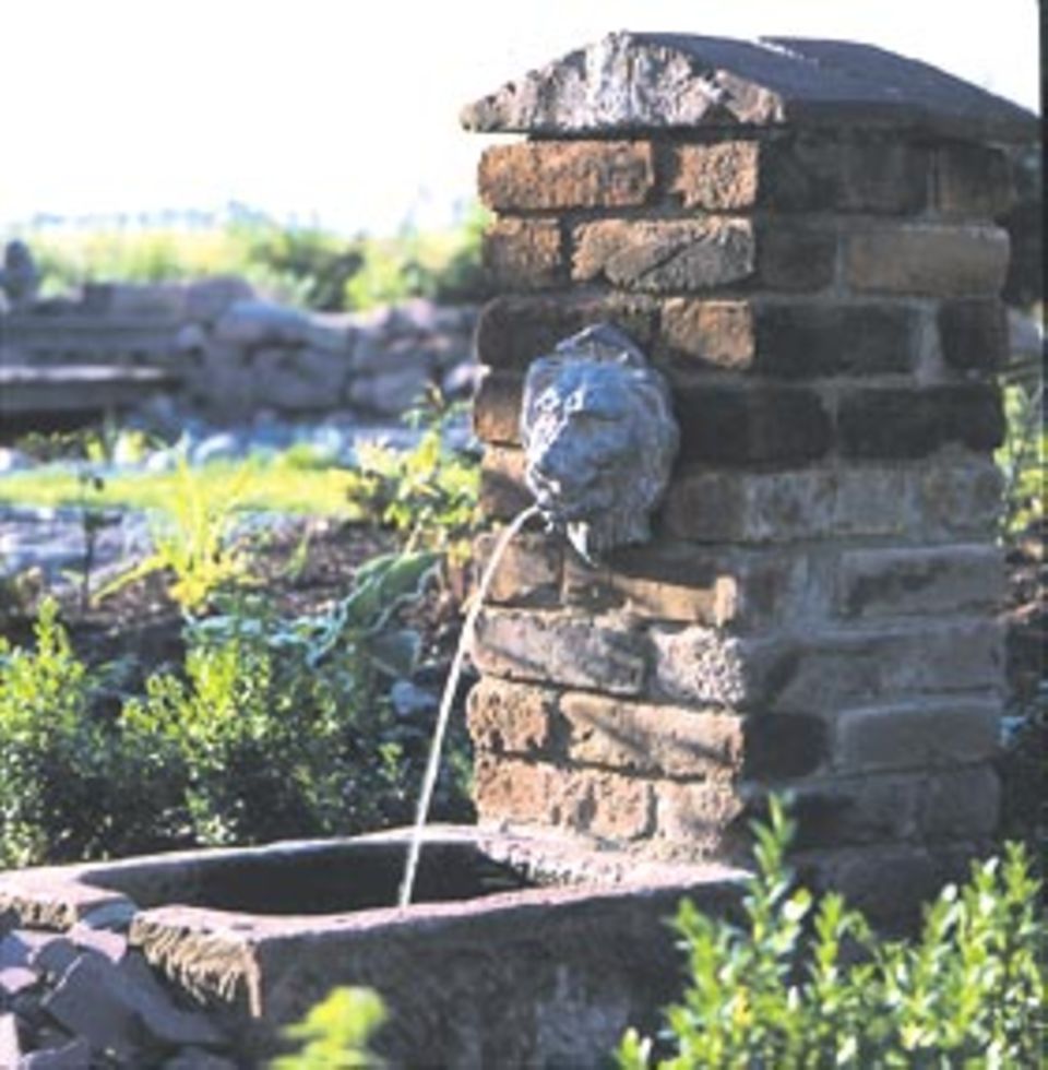 Materialmix Der Brunnen entstand aus recycelten Backsteinen, Teilen einer Mauerkrone, Sandsteintrog und Löwenkopf aus Blei.