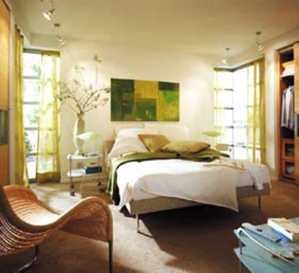 Sanfte Grüntöne zu Weiß sorgen für Entspannung im Schlafzimmer und erinnern an Frühling. Die schlichten Wände und Decken erlauben ein Farbspiel quer durch die Grünpalette - von dem ins gelbliche gehendem Lindgrün der Vorhänge bis zum Moosgrün in der Tagesdecke. Geschickt vereint sind alle Töne dann im Bild über dem Bett. Ideale Ergänzung: Schlicht gehaltene Möbel in hellen Naturfarben.