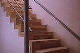 Treppenskulptur aus zyprischem Sandstein. Der warme Farbton des Natursteins belebt die weißen Flächen an Treppe und Wänden. Die fein gegliederten Stufen sind aus einem massiven Stück geformt. (Entwurf: David Chipperfield)