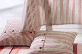 Streifzüge durch die Bettenlandschaft - auf dieser Pirsch fallen die Kissenhüllen mit roten und weißen Streifen natürlich ins Auge. Breit oder schmal gestreift fühlen sie sich am wohlsten in einer gemütlichen Kuschelecke. Detailinformation und Bestellmöglichkeit