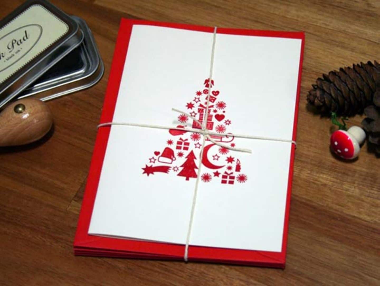 Weihnachtskarte mit aufgedrucktem roten Tannenbaum