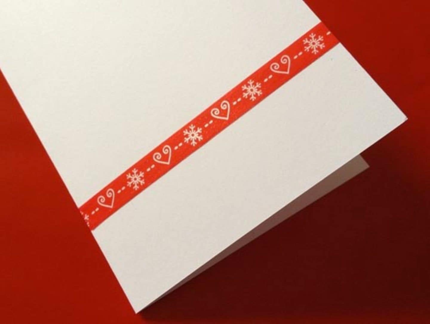 Weihnachtskarte mit rotem Geschenkband