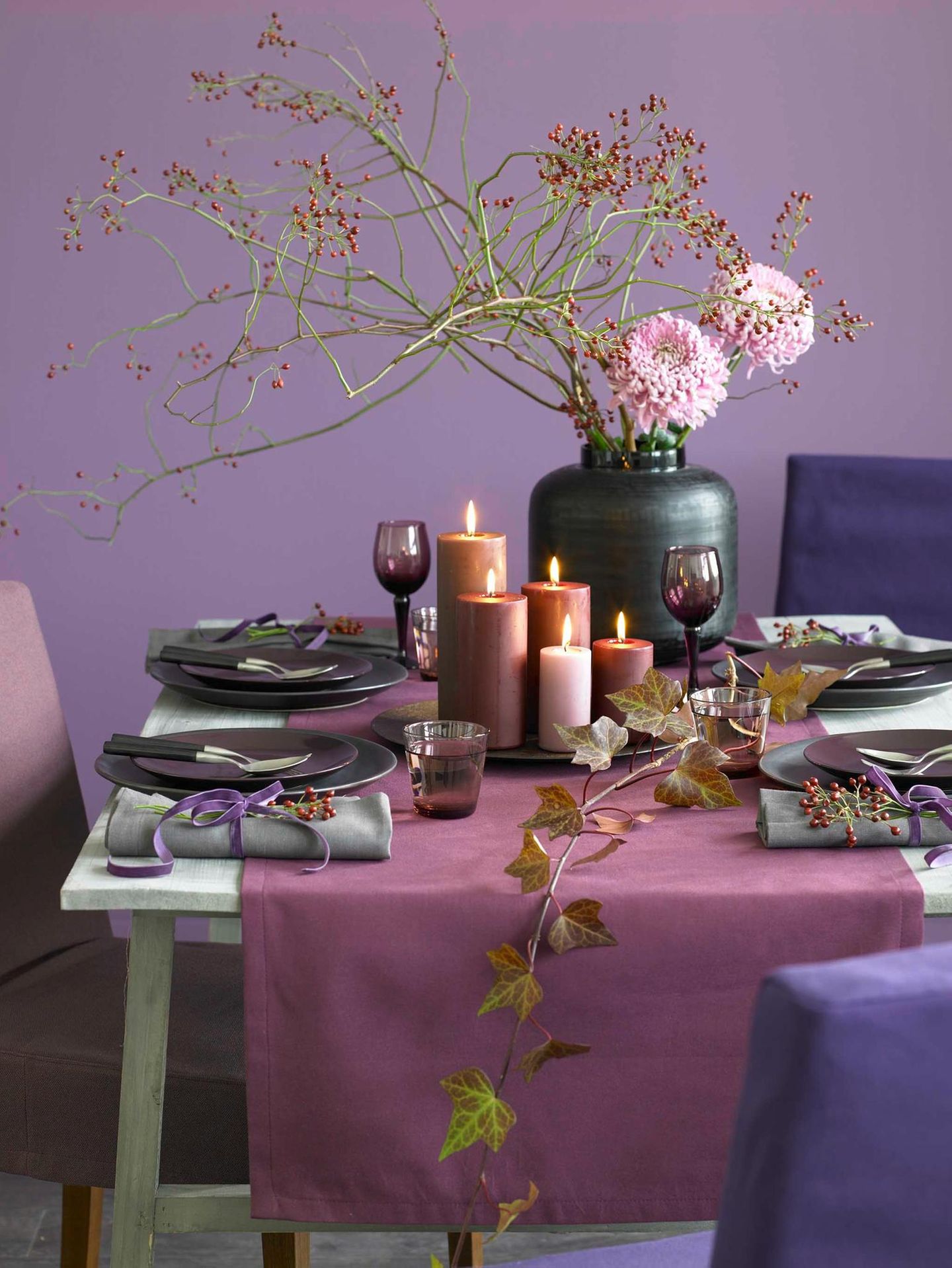 Tischdeko mit Kerzen in verschiedenen Lila-Tönen