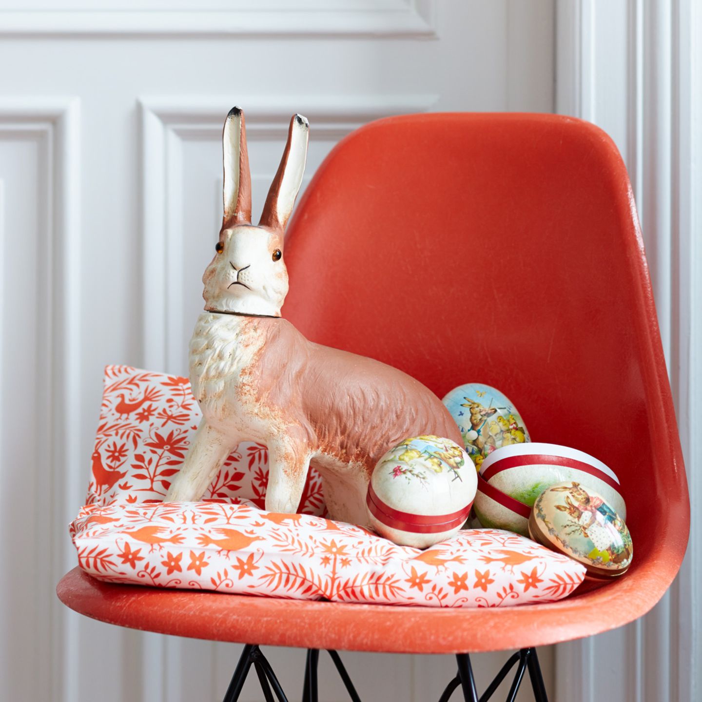 Deko-Osterhase auf einem roten Stuhl