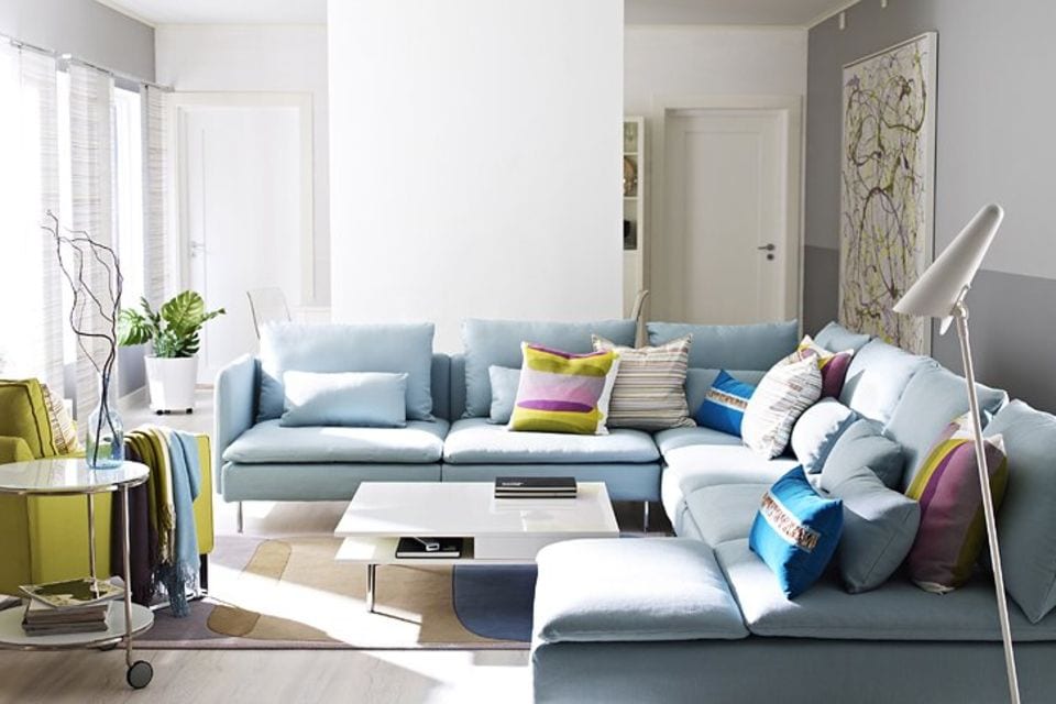 Sofa in Hellblau mit farbigen Kissen