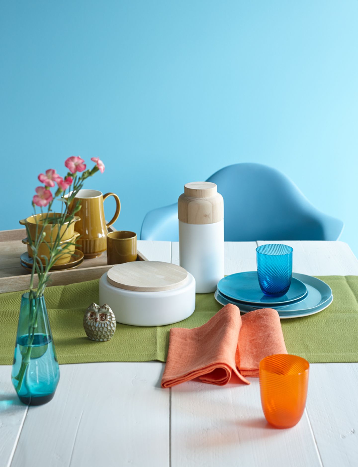 Geschirr in Blau und Grün, Servietten und Glas in Orange
