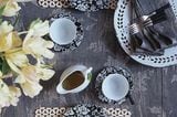 Porzellangeschirr, Tischsets und tischdecke mit Blumenmuster in Grau
