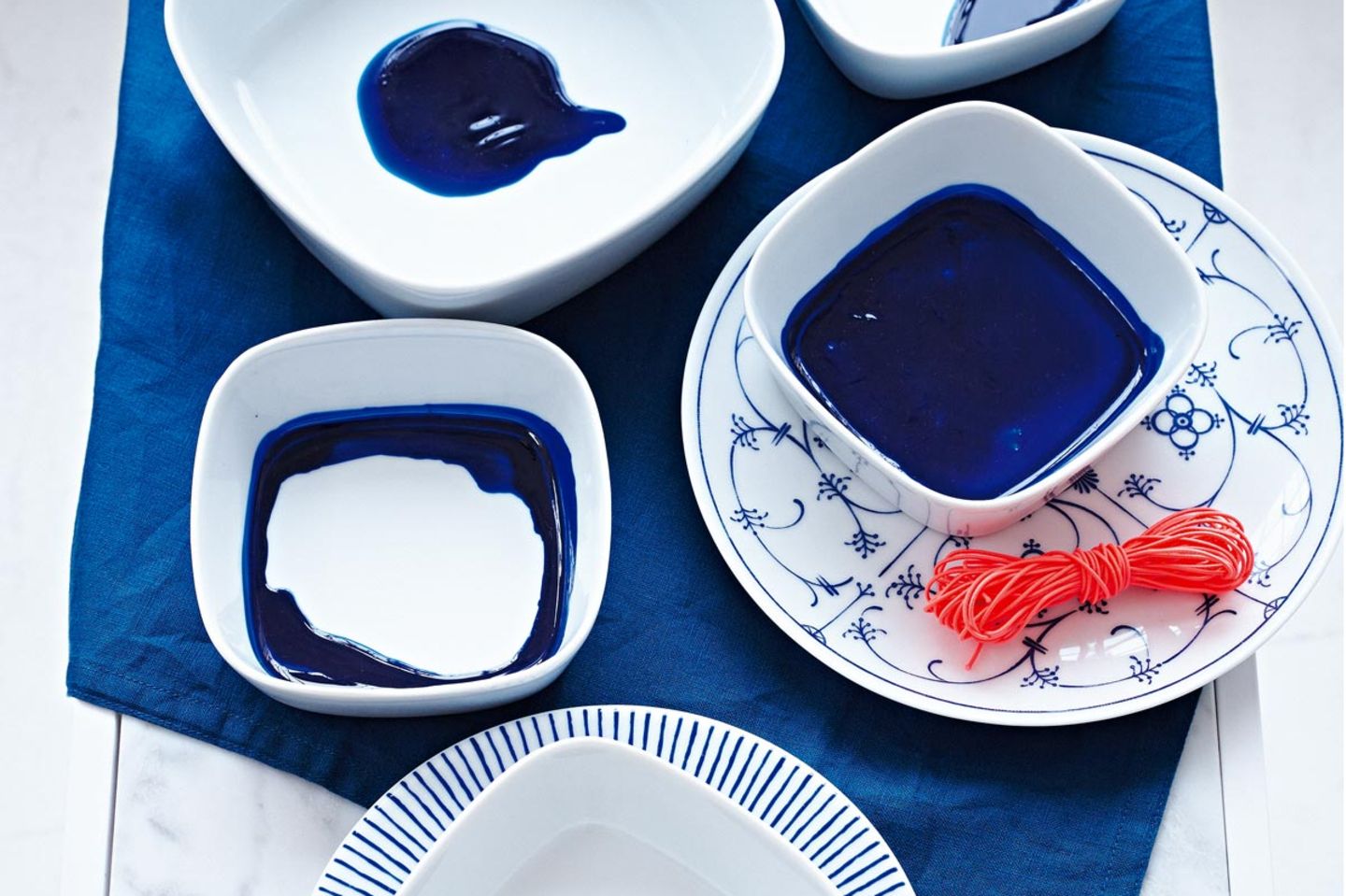 Weißes Geschirr verschönert mit blauer Prozellanfarbe