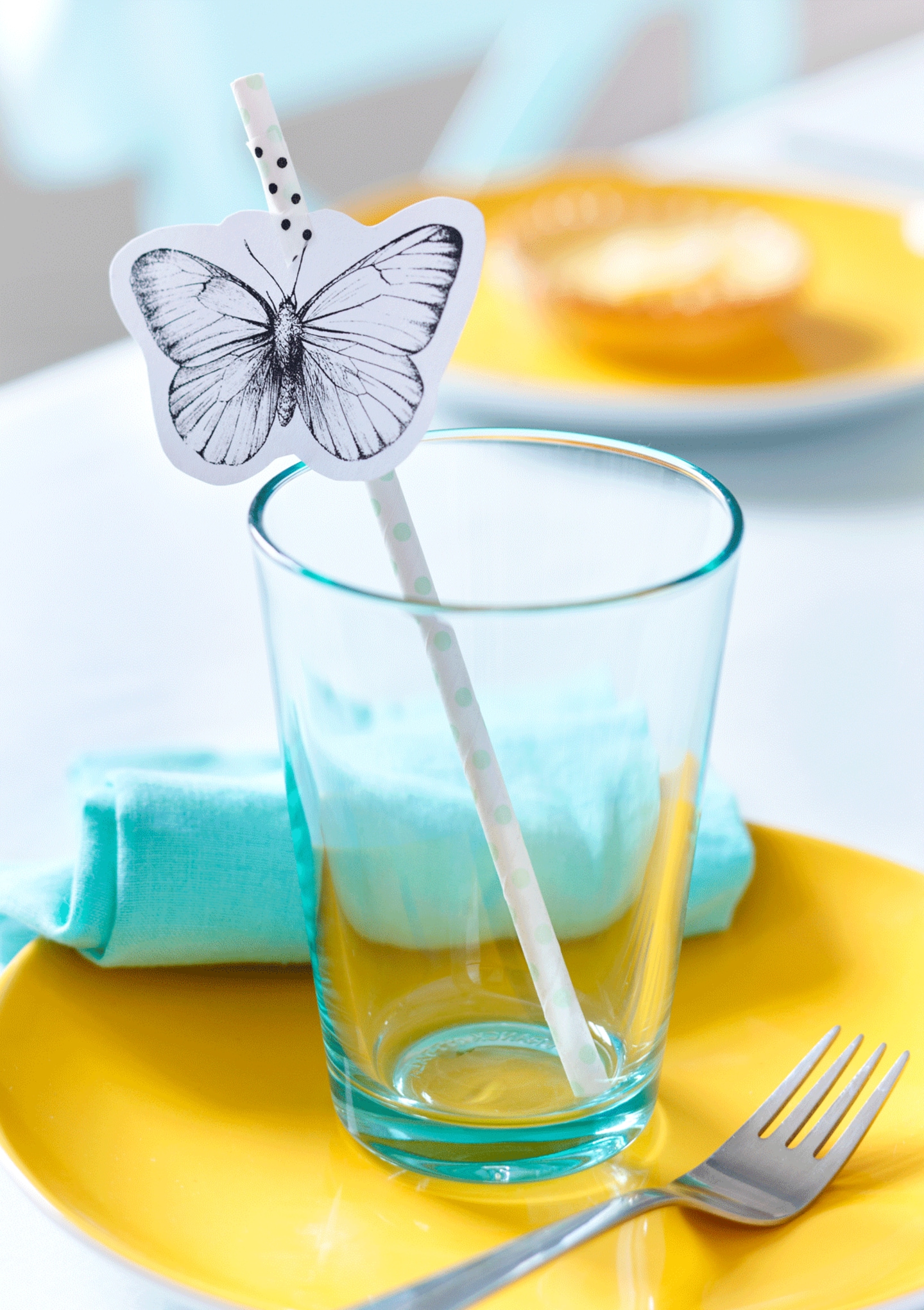 Strohhalm mit Schmetterlingsdeko im Glas
