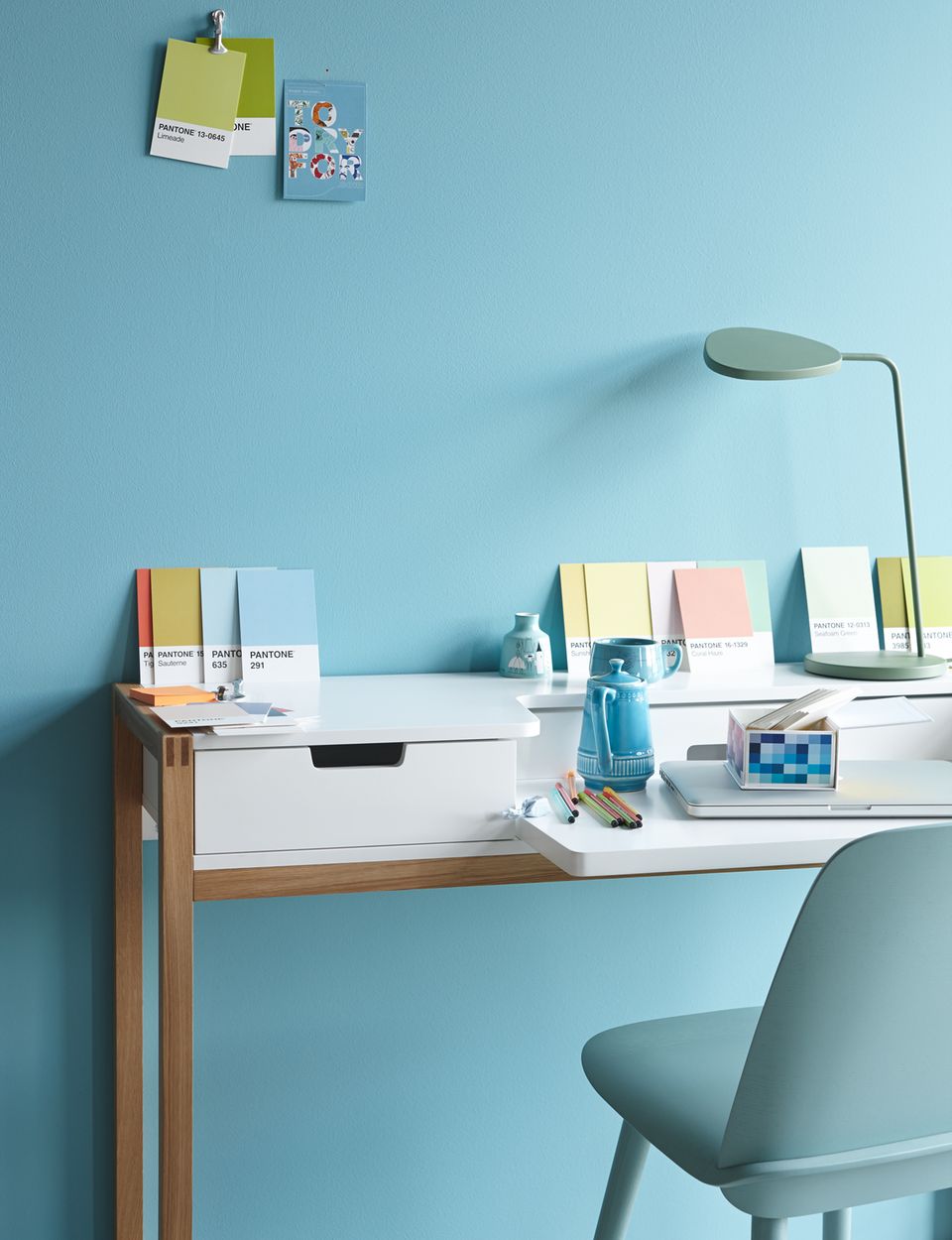 Schreibtisch in Weiß vor blauer Wand