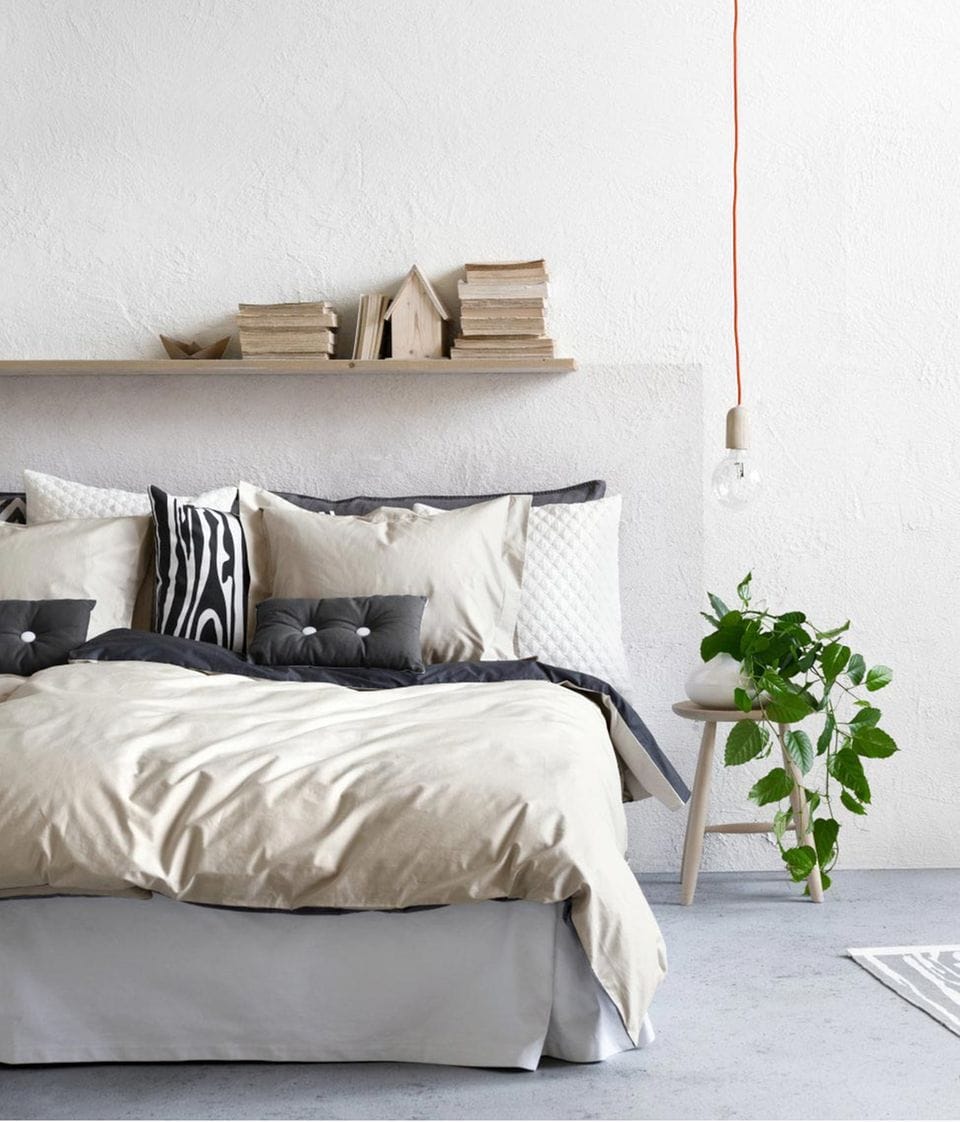 Schlafzimmer mit weißen Wänden und Textilien in Naturfarben