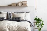 Schlafzimmer mit weißen Wänden und Textilien in Naturfarben