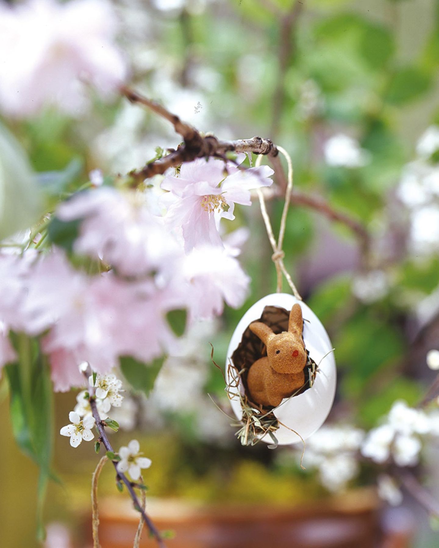 Osterhäschen in Eierschale am Blütenzweig