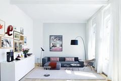 Sofa in Grau vor weiß gestrichenen Wänden