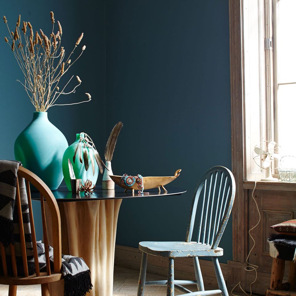 Wandfarbe Petrol und moderner runder Esstisch und Stühle aus Holz