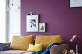 Wand in Lila und ein Sofa in Braun und Gelb