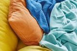 Kissen in Gelb und Orange sowie Decken in Balu und Türkis