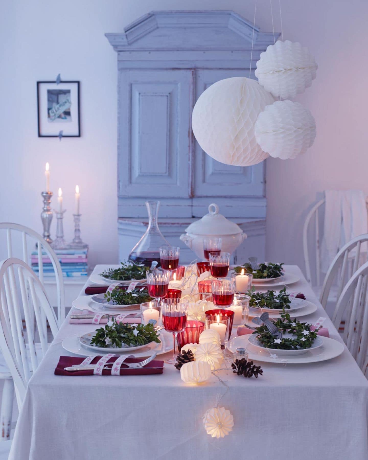 Gedeckter Festtafel fürs Weihnachtsmenü in Weiß, Silber und Rot