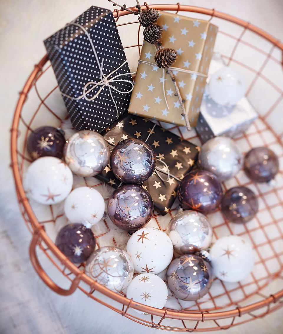 Weihnachtskugeln mit Sternen von Gingar in einem Drahtkorb mit Geschenken