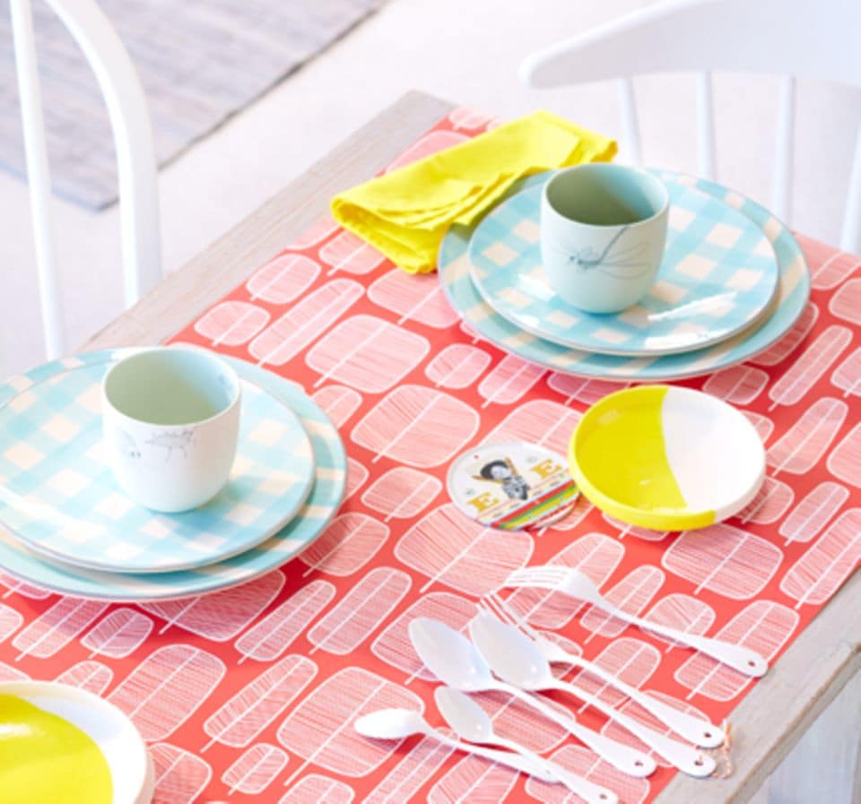 Eine farbige Tapete peppt den Gartentisch auf und ist gleichzeitig die Tischdecke.