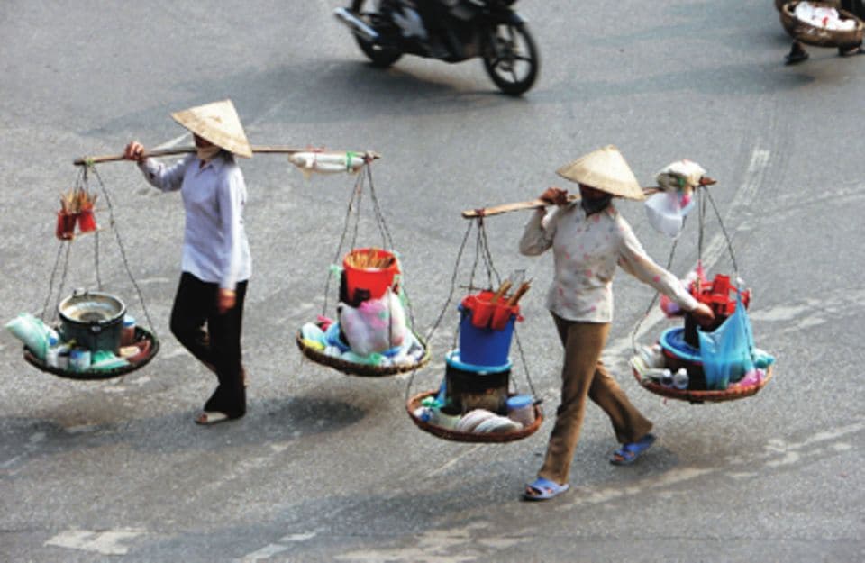 Vietnamesische Straßenköchinnen: Mit wenigen Utensilien zaubern sie Pfannkuchen und andere Köstlichkeiten. Foto: iCEO/Shutterstock