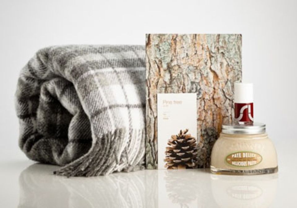 Das Paket "Baby it's cold outside" enthält eine kuschelige Decke, einen Nagellack von COS, ein Notizbuch und ein Mandel-Körperpeeling von L'Occitane en Provence.
