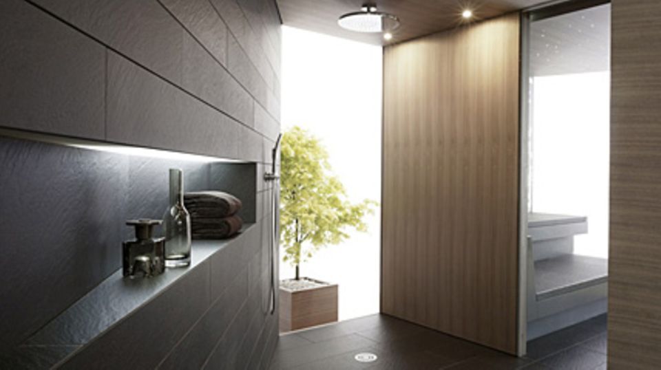 "Tangram" verbindet die Kabinen optisch mit dem in schwarzem Naturstein gehaltenen Dusch- und Abkühlungsbereich. Foto: Klafs