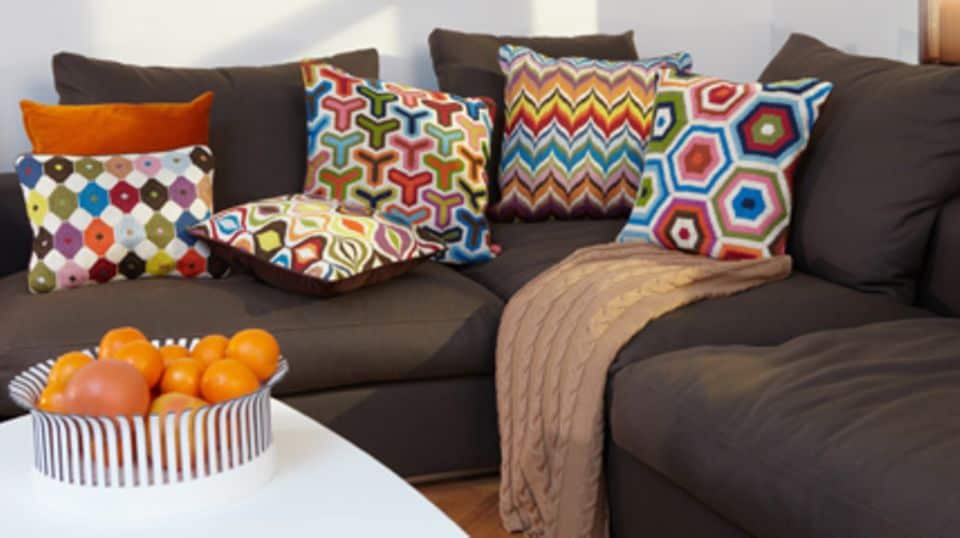 Die gemusterten Kissen von Jonathan Adler bringen Farbe auf die Couch! Foto: Tischwerk