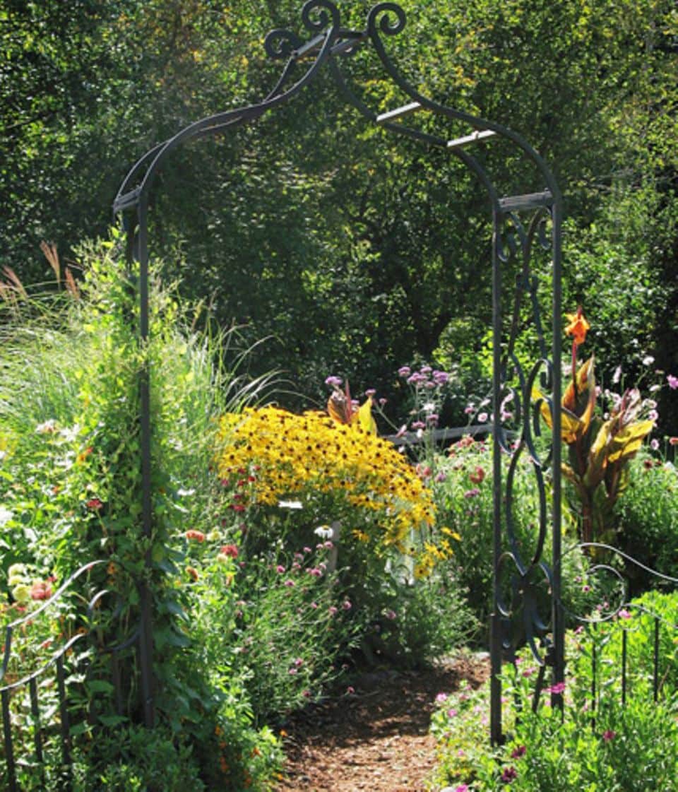 Ein Torbogen ist ein idealer Übergang von einem Gartenraum zum nächsten.