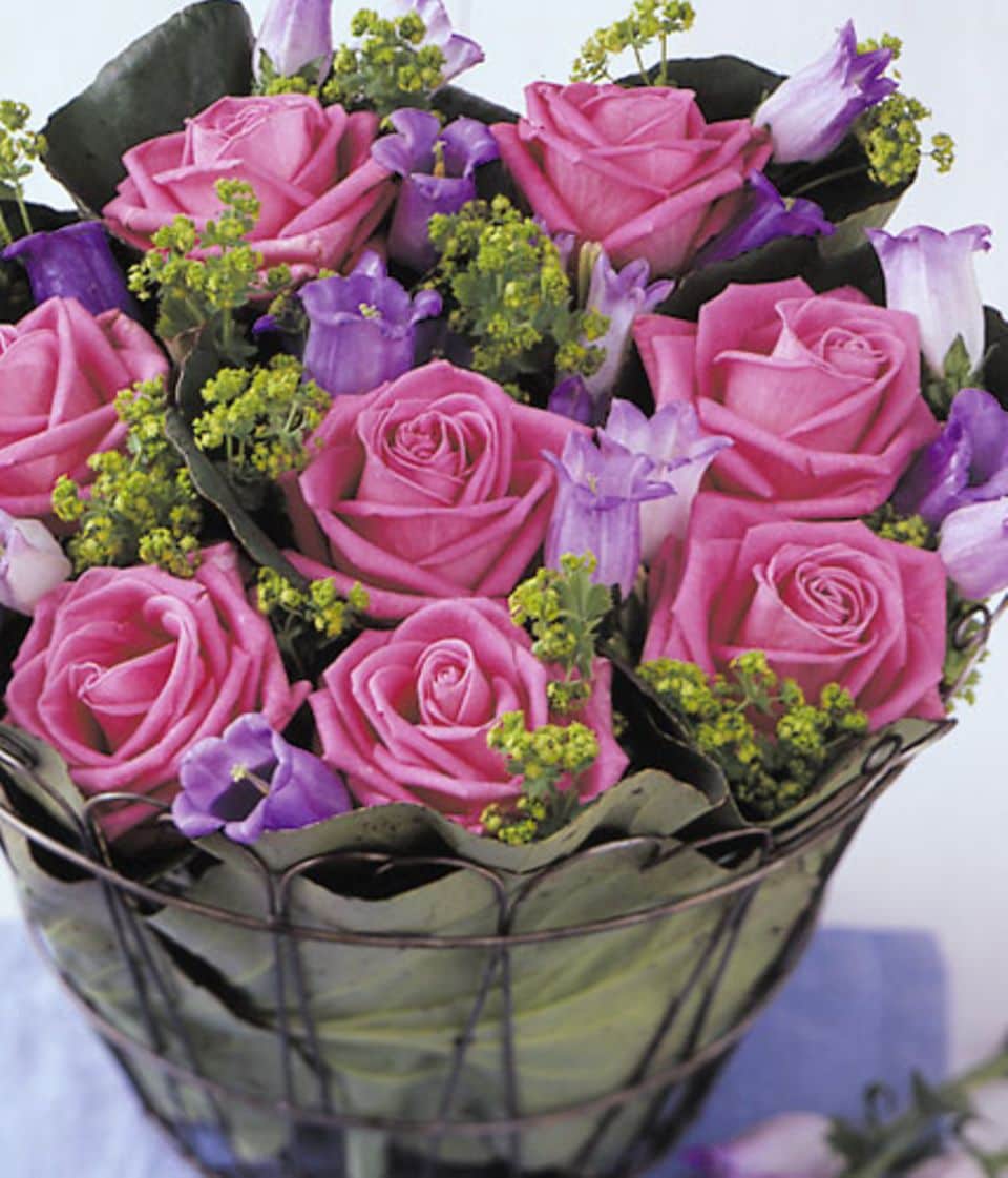 Gebin­de aus Rosen, Marienglockenblumen und Frauenmantel werden zu einem dichten Strauß zusammengesteckt