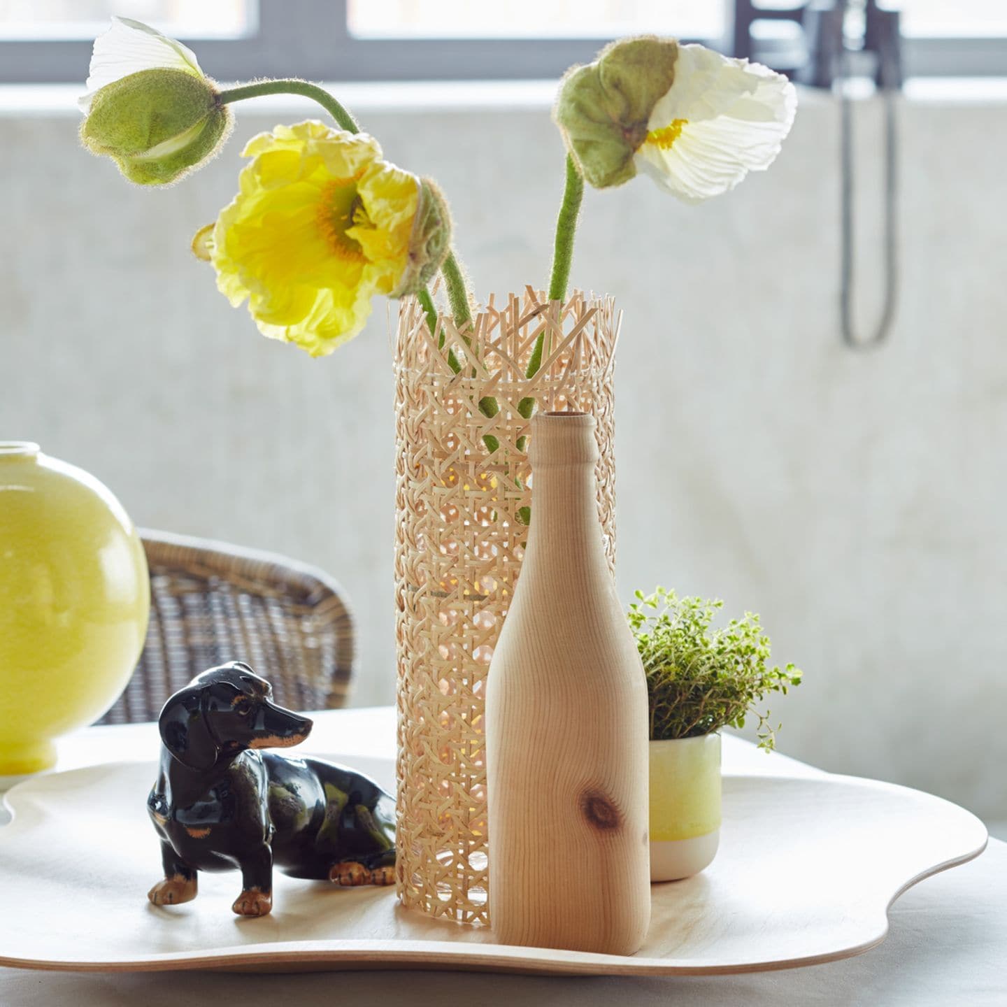 Vase aus Rattan. Tischdeko in sommerlichem Gelb