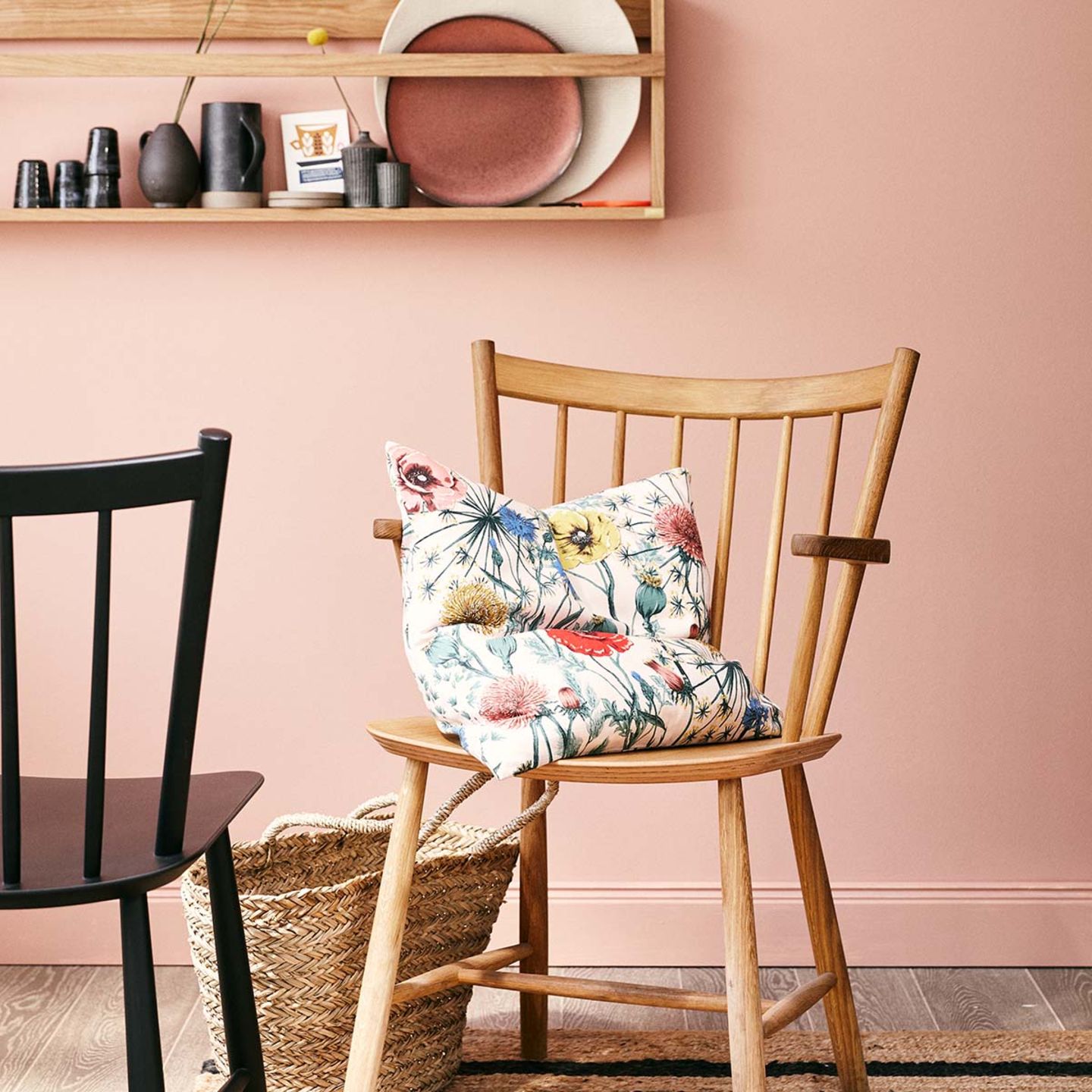 Rosa Wandfarbe mit Holzstühlen und geblümten Kissen