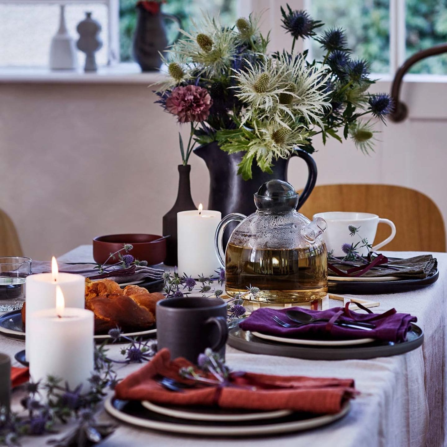 Tischdeko mit Blumen und roten und lilanen Servietten