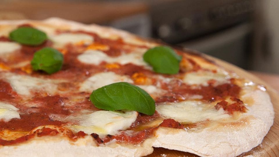 Pizzateig belegt mit Tomatensauce und Mozzarella