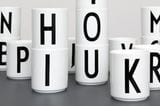 Weiße schlichte Tassen mit schwarzen Buchstaben