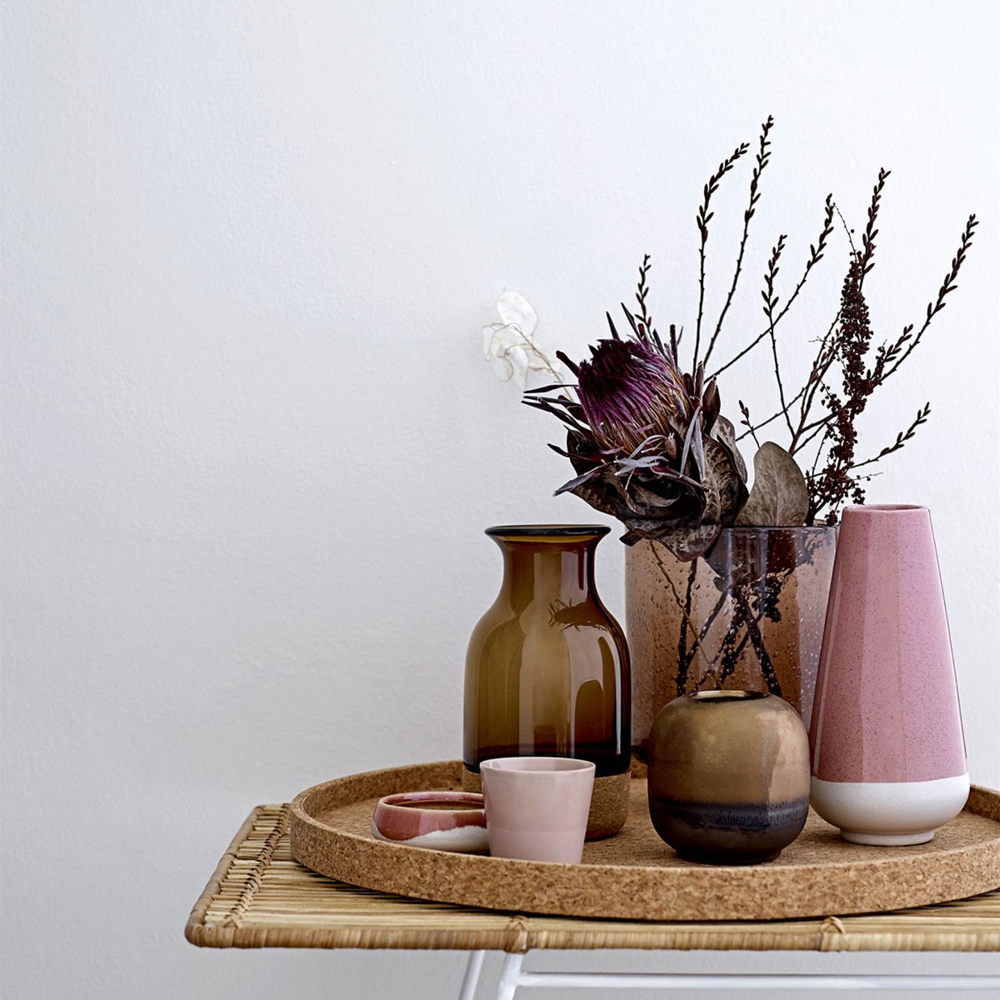 Korktablett mit verschiedenen Vasen und Schälchen in Braun und Rosa