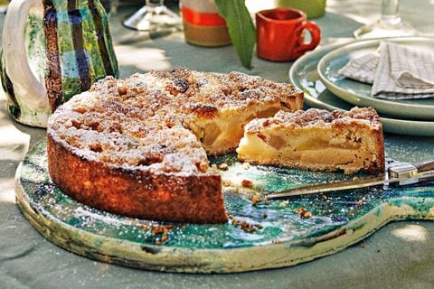 Kuchen mit Streuseln und Apfel auf einem blauen Keramikbrett bei herbstlich anmutender Tischdekoration