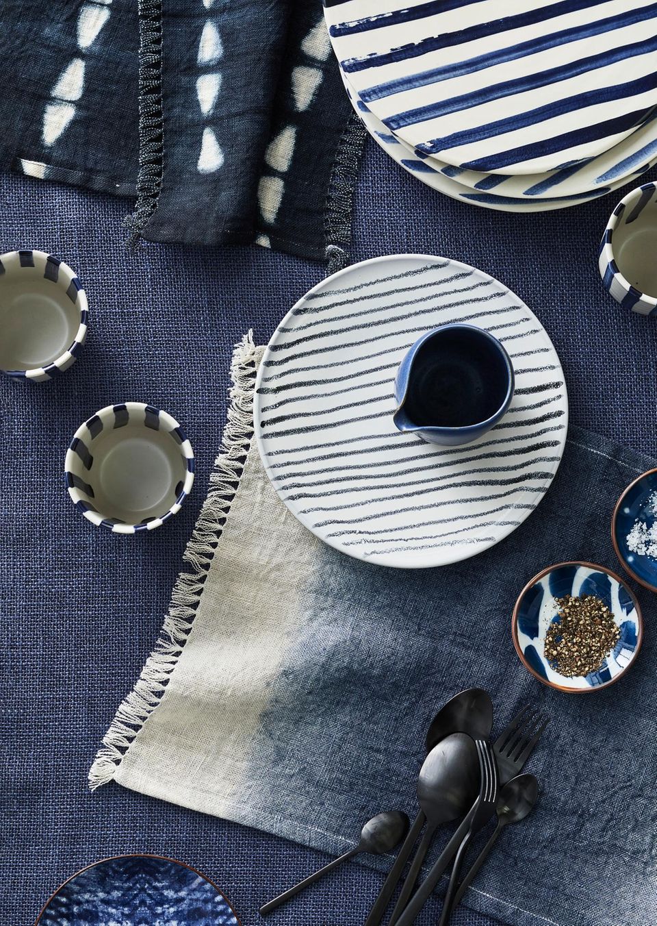 Gedeckter Tisch mit Keramik und Textilien in Blau und Weiß