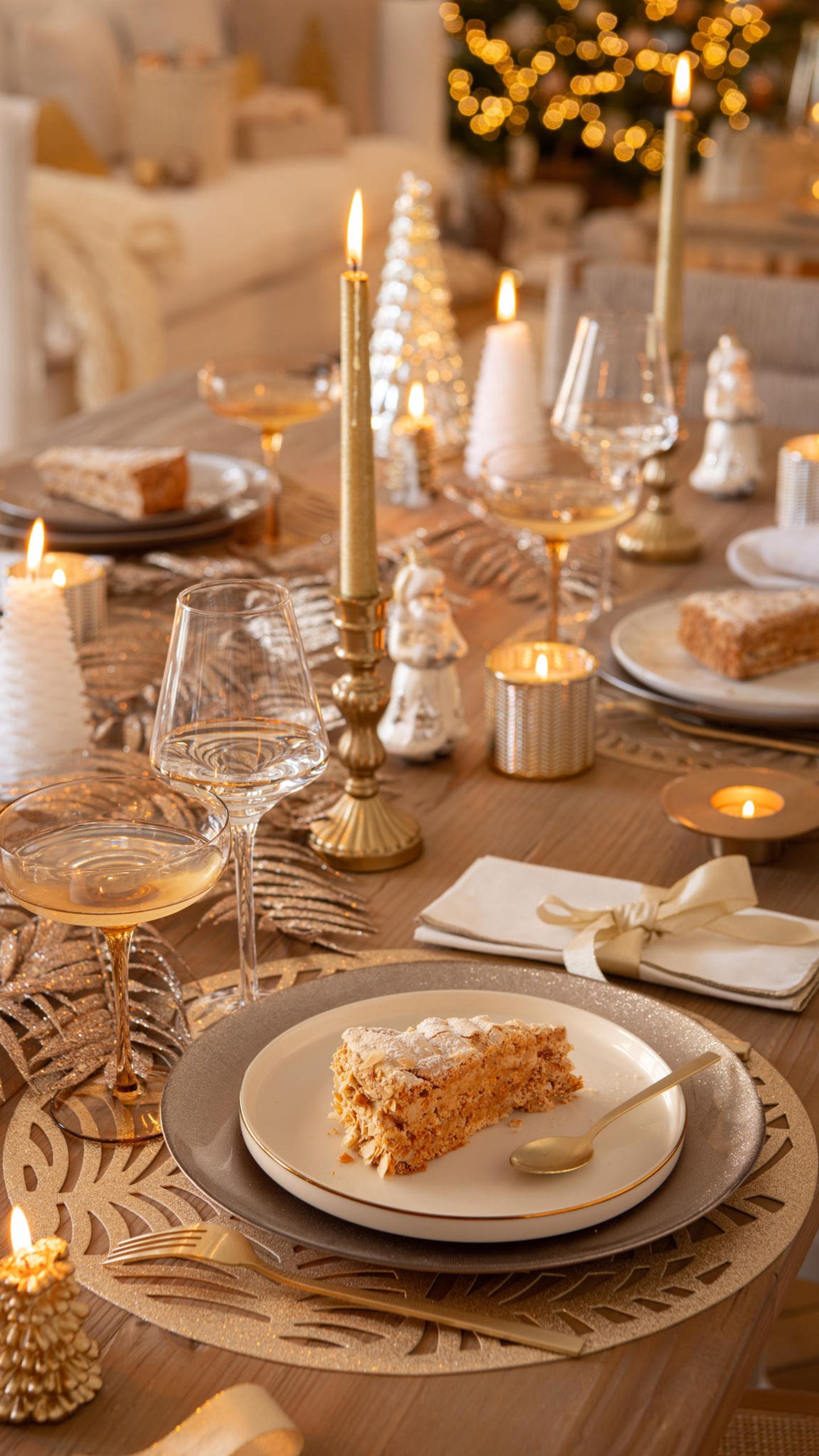 Tischdeko auf rustikalem Holztisch mit goldenen Platzdecken, Kerzenhaltern und Windlichtern