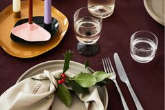 Weihnachten kann mehr als klassisches Grün-Rot-Weiß. Deko in organischen Formen ist im Trend und lässt sich prima für eine moderne Weihnachtsdeko zweckentfremden. Die Kerzenhalter in verschiedenen Größen und Farben sind der Hingucker auf der bordeauxroten Tischdecke. Dabei darf die Farbenkombination auch gerne etwas gewagter sein: Gewürztöne treffen auf kräftiges Rosa und Kerzen in Flieder- und Erdtönen. Damit es auf dem Tisch nicht zu wild wird, gesellt sich schlichte Keramik in hellen Lasuren dazu. Ein paar Elemente aus der Natur wie Lorbeerzweige verleihen der Tischdeko den finalen Touch.    Kerzenplatten "Mie", in verschiedenen Größen und Farben erhältlich, ab ca. 19 Euro,  Getauchte Spitzkerzen, 8,50 Euro pro Satz  www.brostecopenhagen.com