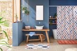 Natürlich anmutendes, geräumiges Bad mit blauen Wänden, Holzfliesen und schöner Deko von Kleine Wolke