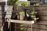 Balkon mit Holzgeländer, Pflanzen und Pflanzenregal