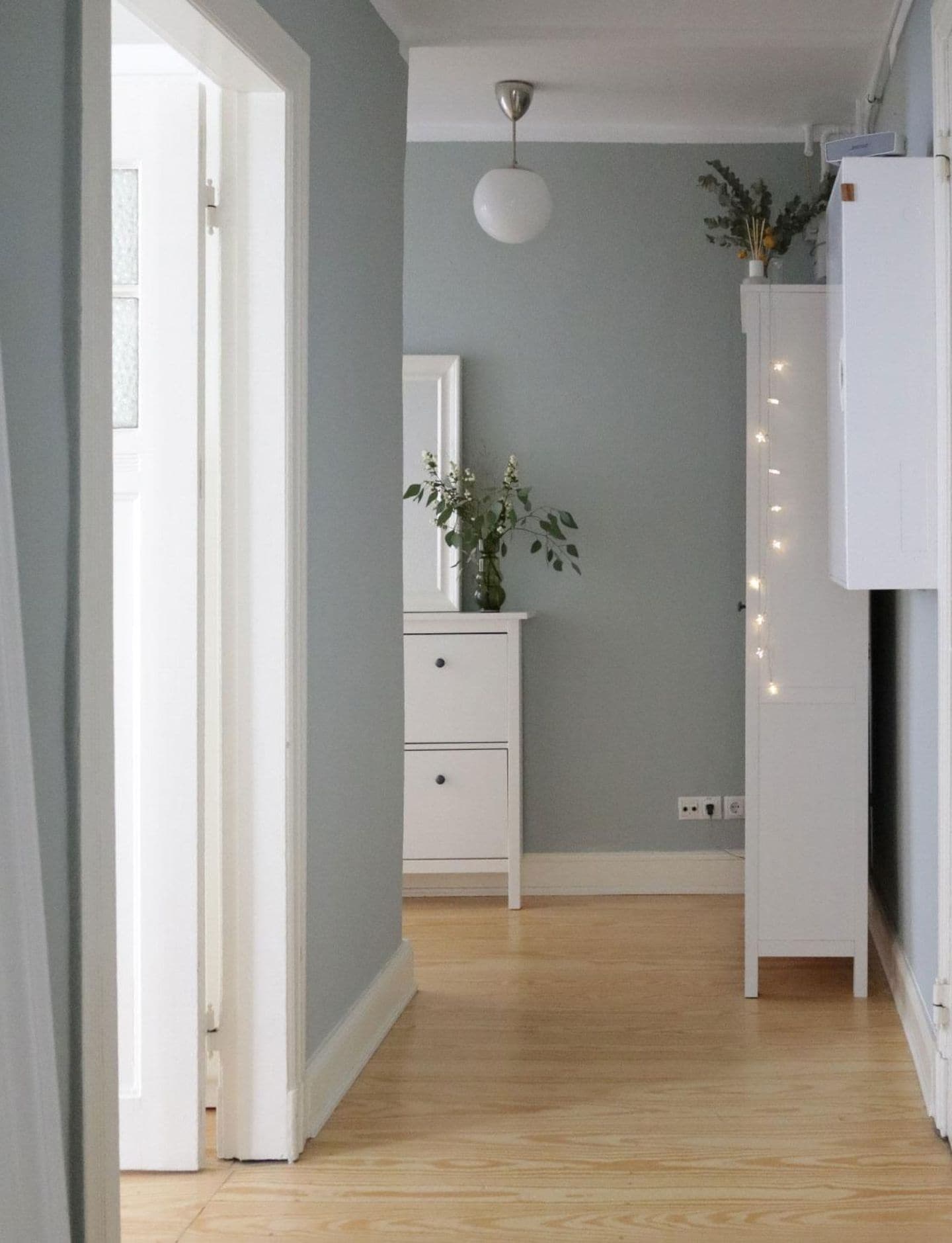 Flur mit Dielenboden, weißen Möbeln und Wänden in Jadegrün von SCHÖNER WOHNEN-Farbe