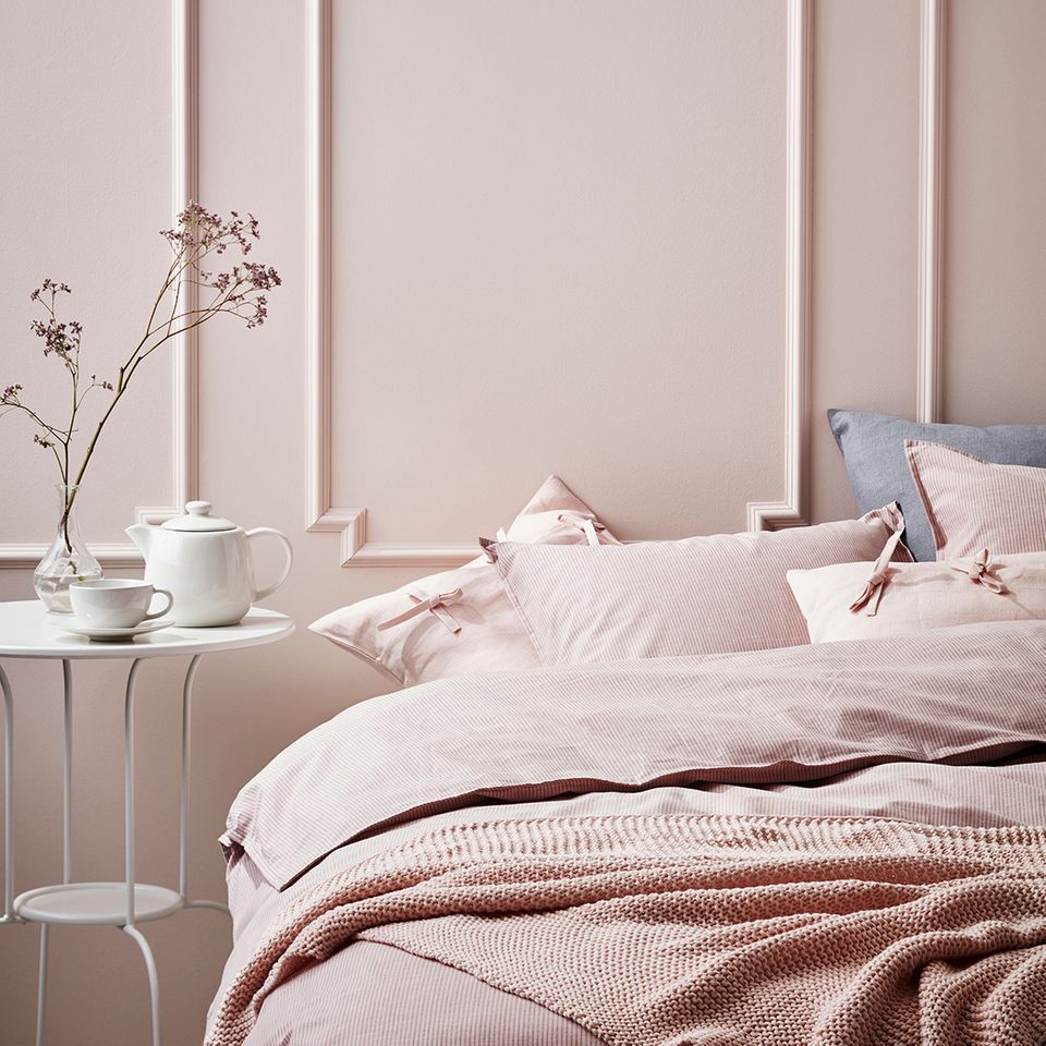 Nahaufnahme eines Bettes und einer Wand komplett in Pastellfarben gehalten