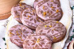 Orangen-Mandel-Lebkuchen liegen auf einem Teller mit rosa Zuckerguss