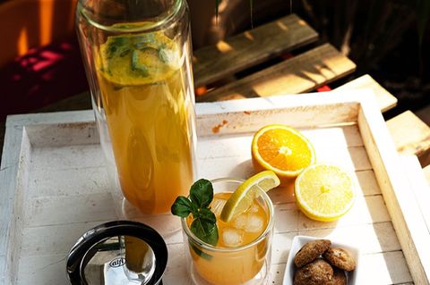 limonade mit zitronen und basilikum in einer glaskaraffe und einem Glas